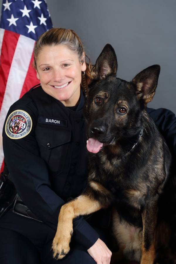 Officer Baron, a white woman in a police uniform, with Hogyn, a large German Shepherd