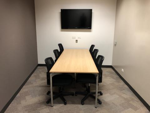 photo of Adult Study Room 2 shows a table with six rolling chairs. A large television is on the wall. Beneath it, electronic inputs are seen.