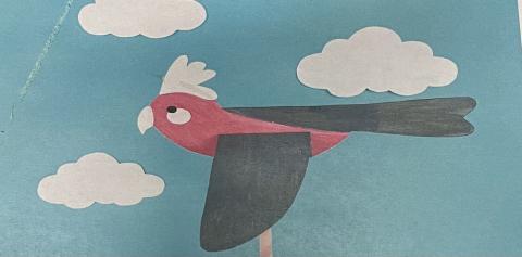 Red and gray paper bird on blue background