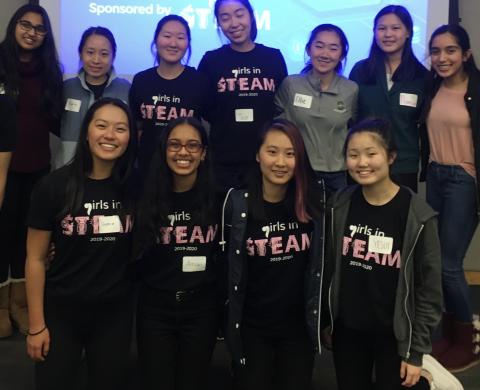 Group of young women in black t-shirts with Girls in STEAM logo.
