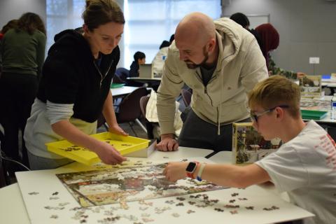 Three people working on a puzzle