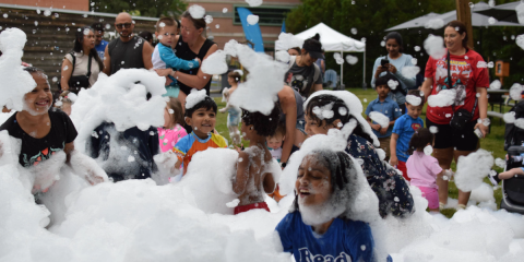 Children and families play in foam outside