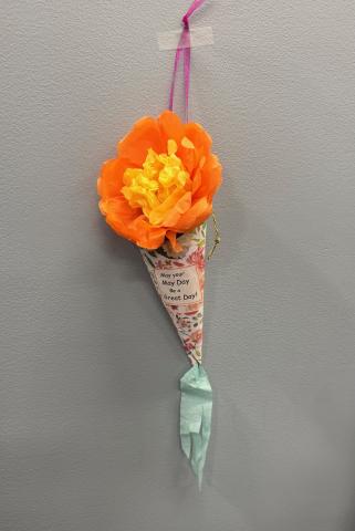 orange and yellow tissue paper flower in a hanging paper basket