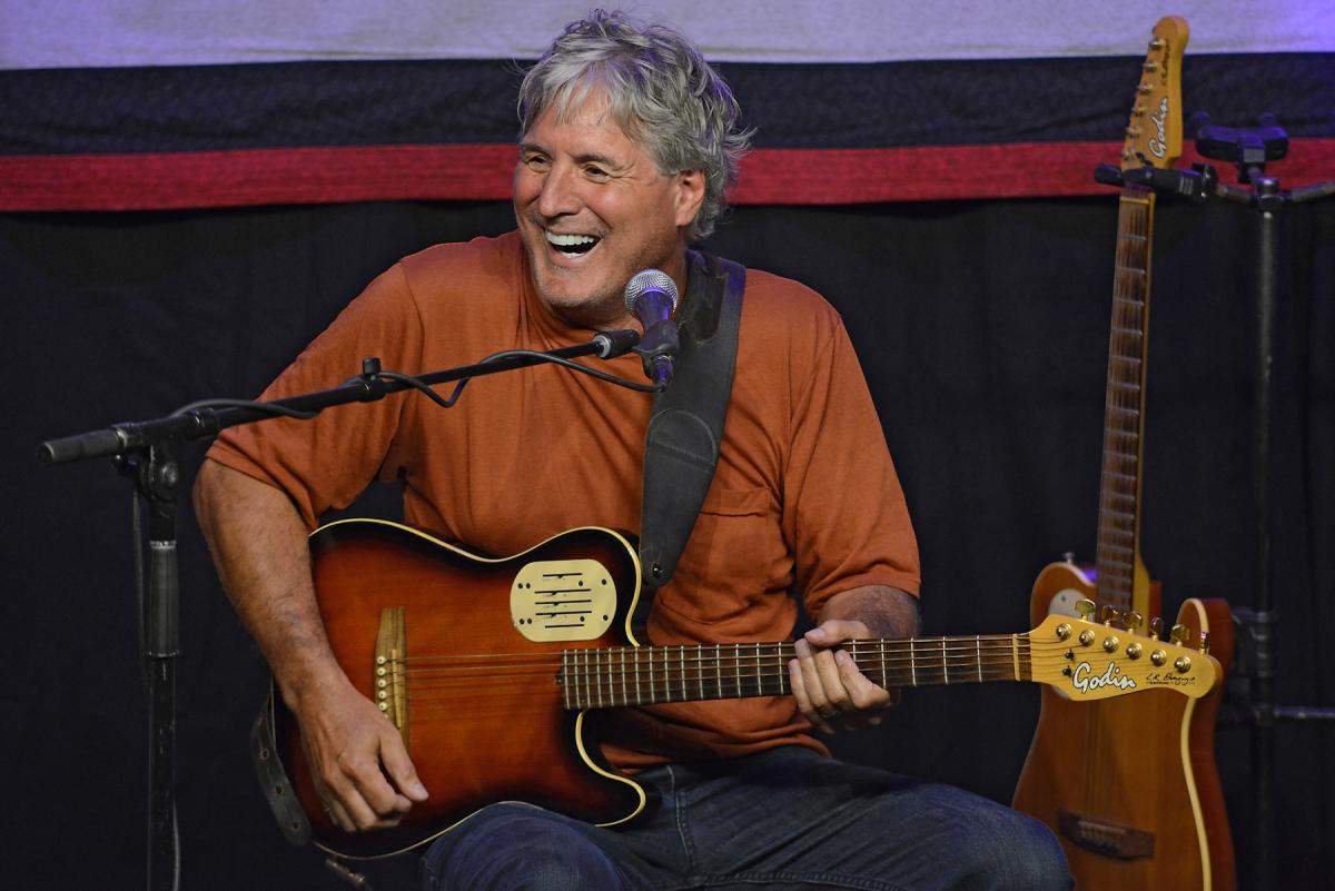 Guitarist Kraig Kenning, who is a white man with grey hair. He holds a guitar.