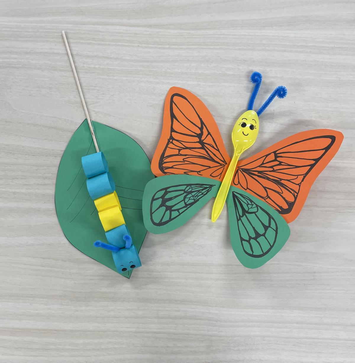 Blue and yellow paper caterpillar on paper leaf orange & green butterfly