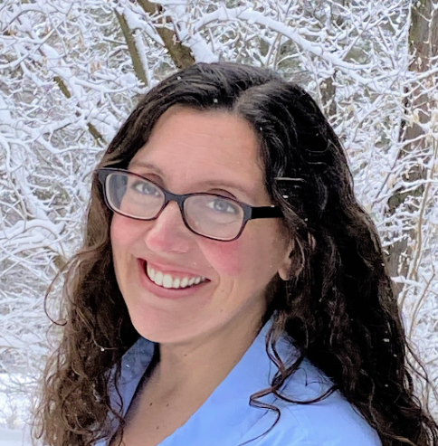 A portrait of Erica Reckamp, a white woman with long dark hair and glasses