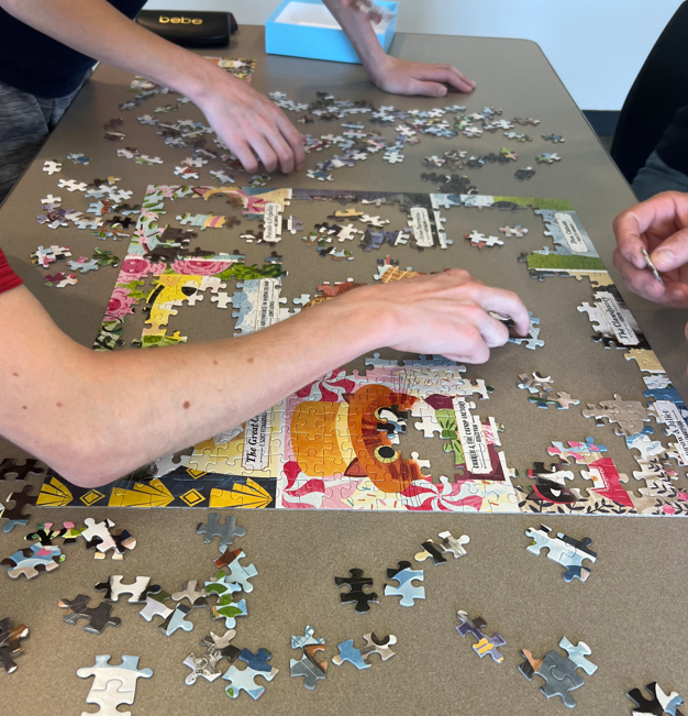 Three people completing a puzzle