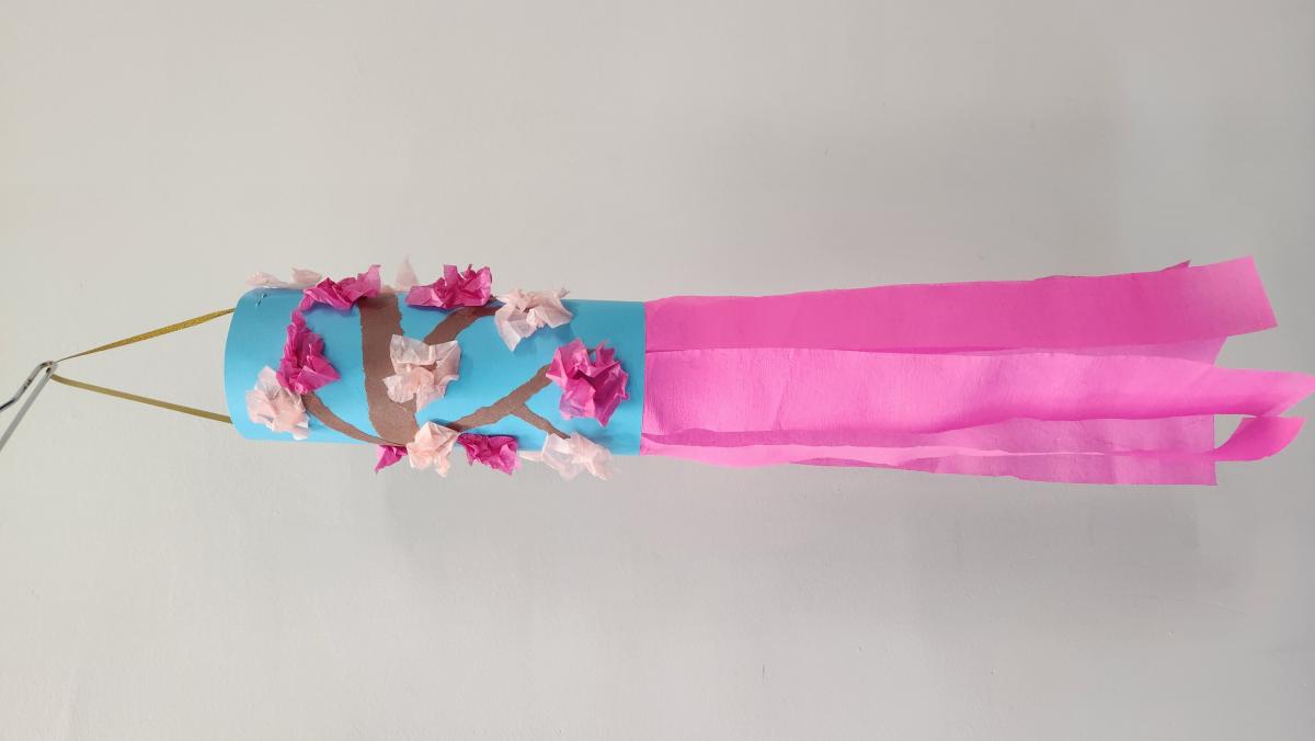 blue paper windsock with pink paper cherry blossoms with pink paper streamers